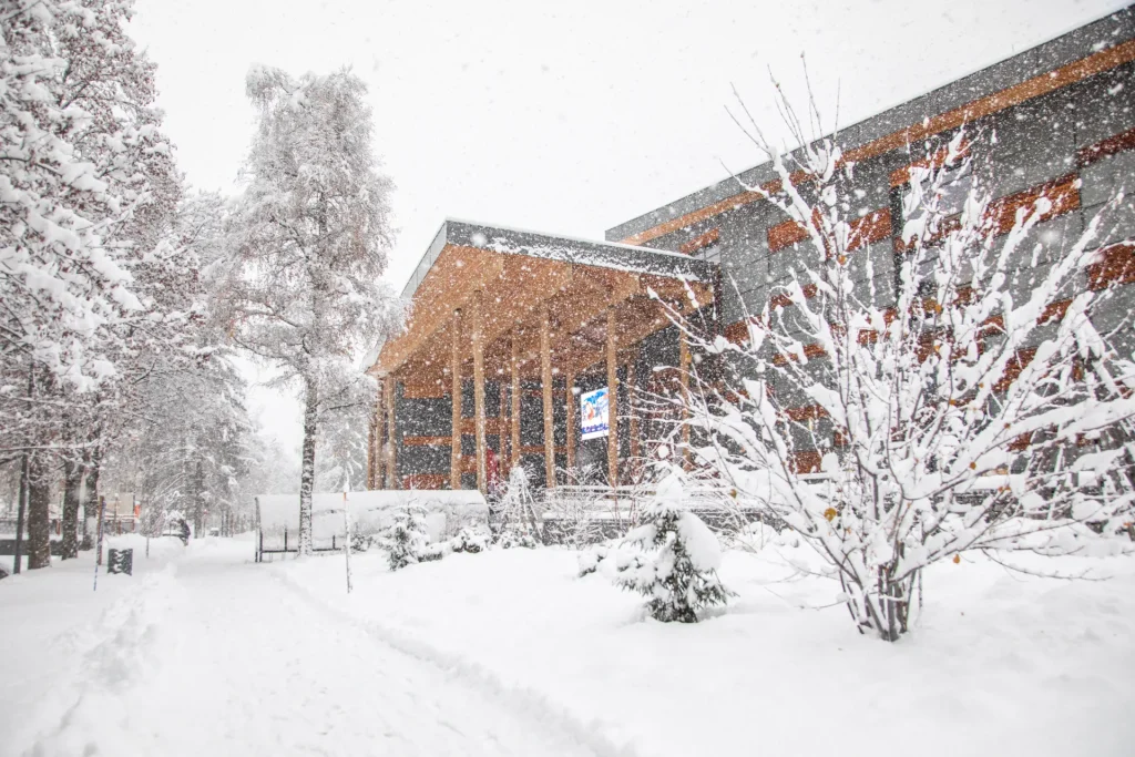 Scène d'hiver avec le bâtiment du palais à Megève et des arbres, tous recouverts d'une épaisse couche de neige.