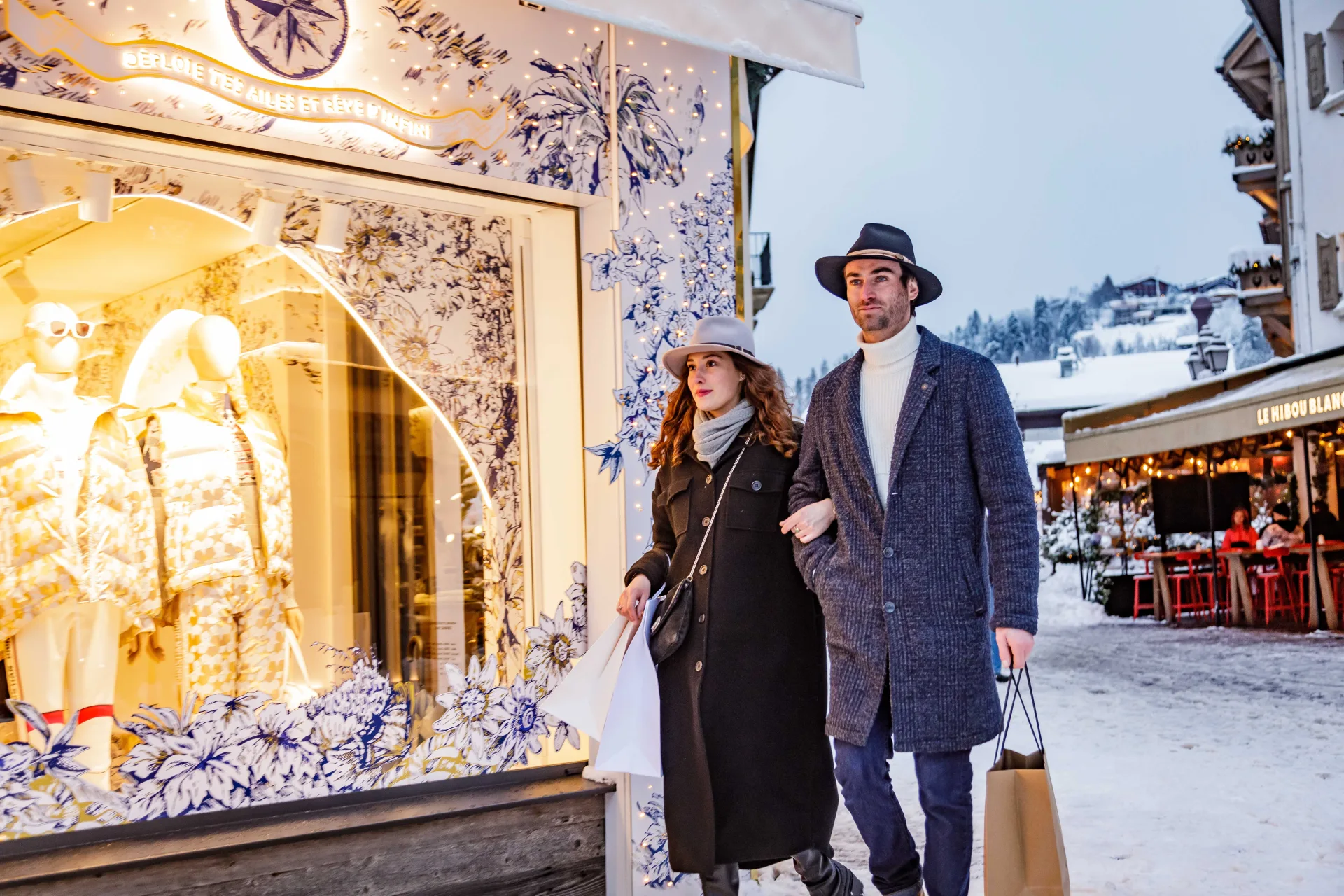 Un couple se promenant sur une rue recouverte de neige, créant une atmosphère romantique et hivernale.