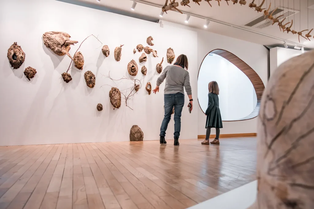 Une maman montre à sa fille une exposition d'art