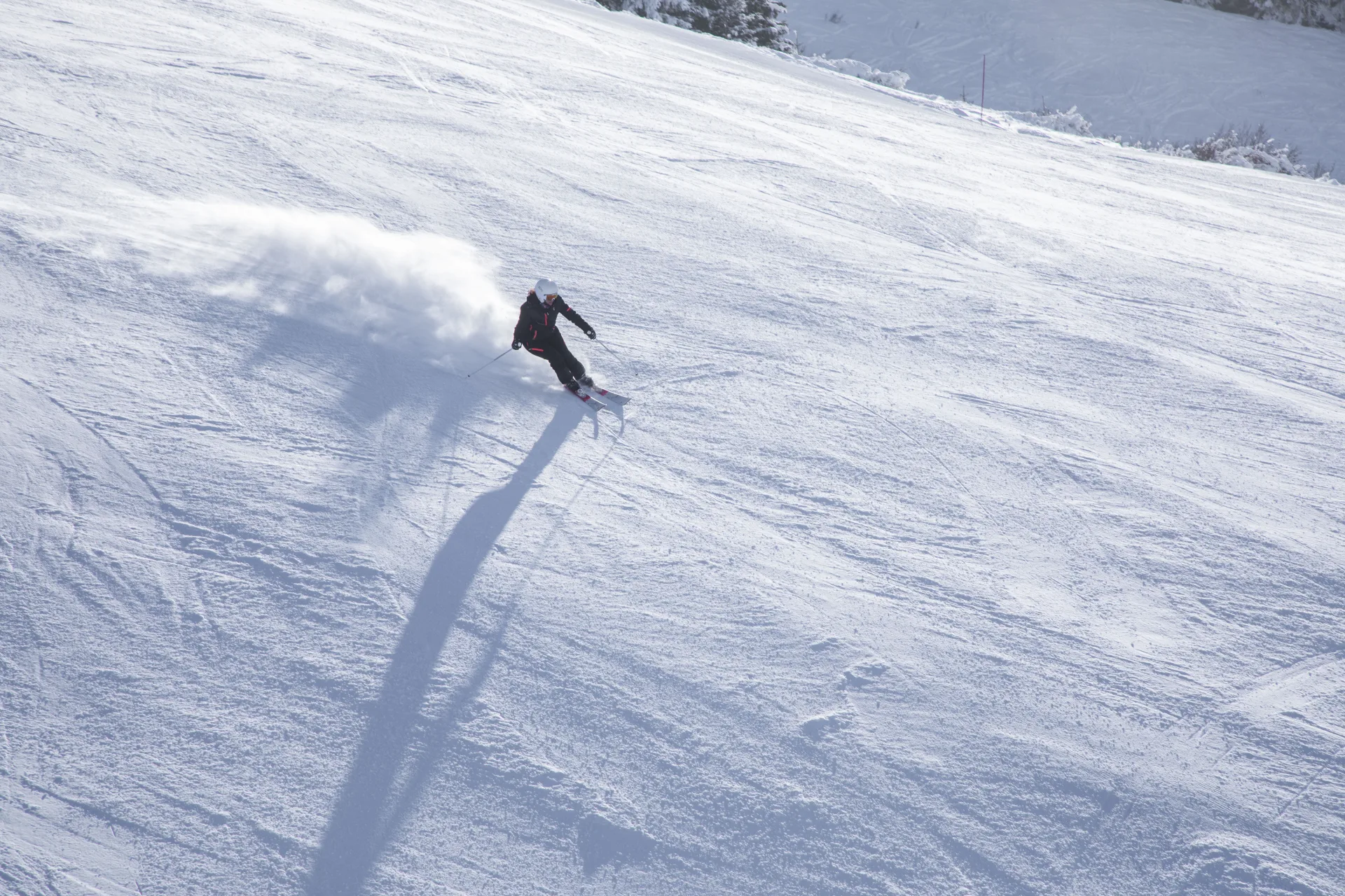 skieuse sur une piste de ski au soleil