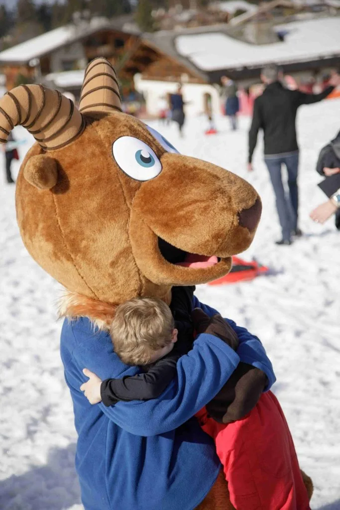mascotte de megève qui caline un enfant