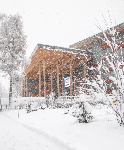 Scena invernale con il palazzo di Megève e gli alberi, tutti ricoperti da uno spesso strato di neve.