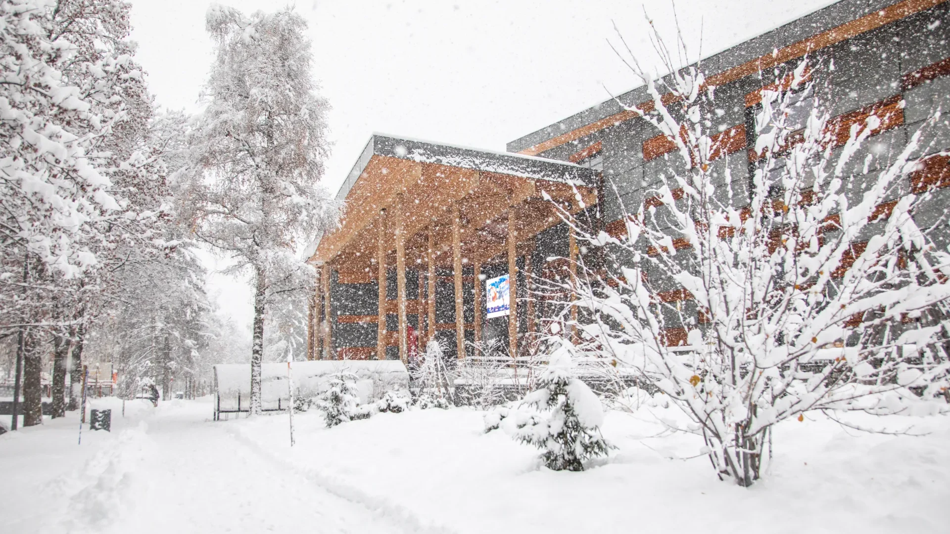 Winter scene with the palace building in Megève and trees, all covered in a thick layer of snow.