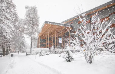 Scène d'hiver avec le bâtiment du palais à Megève et des arbres, tous recouverts d'une épaisse couche de neige.