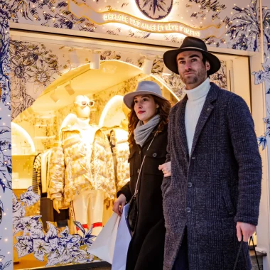 Un homme et une femme marchent ensemble devant une boutique, illustrant une sortie agréable.