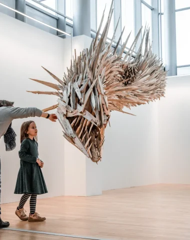 Une maman montre à sa fille une sculpture d'art