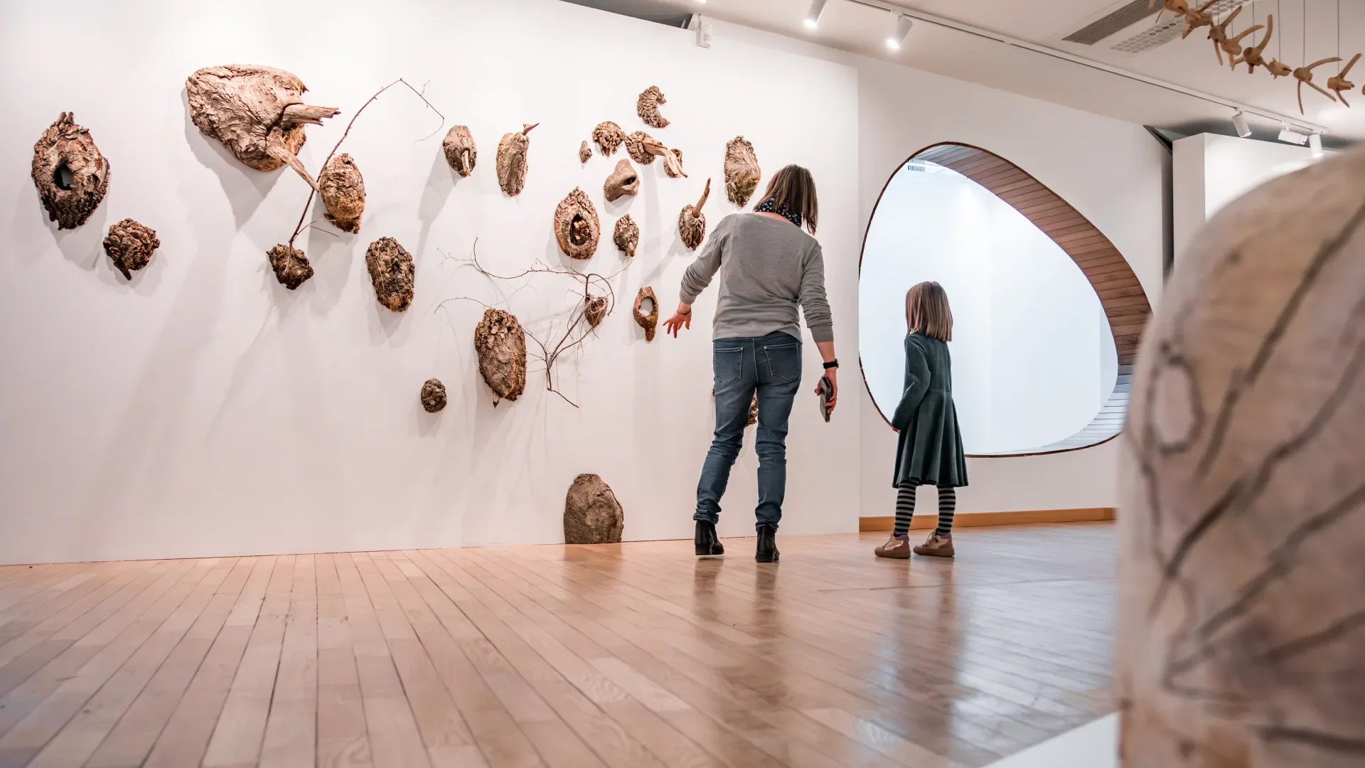 Une maman montre à sa fille une exposition d'art
