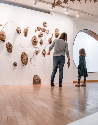 Une maman montre à sa fille une exposition d'art