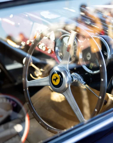 volant d'une vieille voiture de collection Ferrari lors du concours de l'élégance à megève