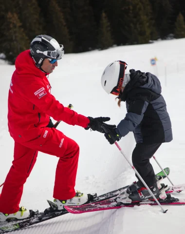 moniteur de ski apprennant à un enfant à skier