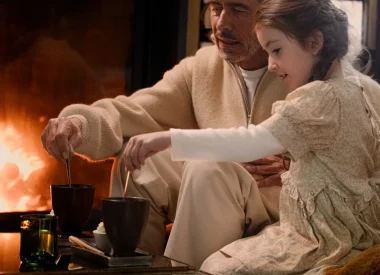 Ouvrir dans la galerie:  grand père et sa petite fille qui boivent un chocolat chaud devant un feu de cheminée