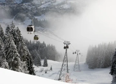 Ouvrir dans la galerie:  cabines de remontées mécaniques dans le brouillard avec un paysage enneigé