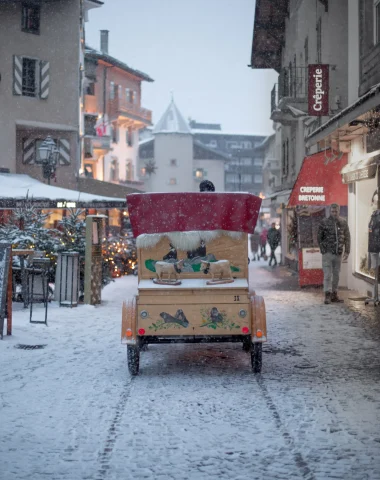 Calèche tirée par un cheval dans le village de Megève sous la neige
