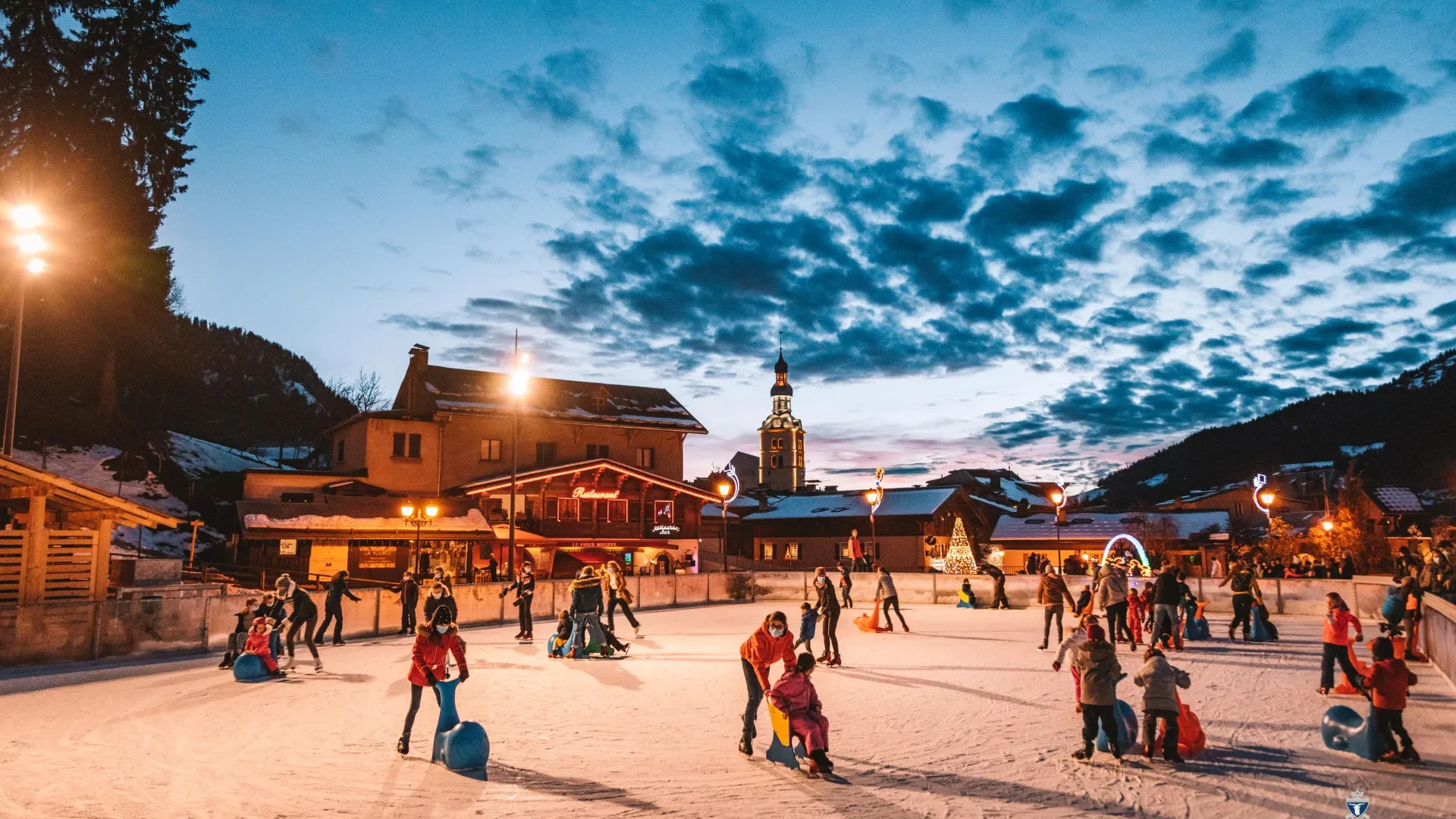Enfants et famille qui patinent à l'éxtérieur à Megève