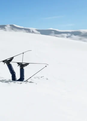 Skieur enfoui dans la neige les ski en l'air et la tete sous la neige