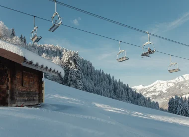 Ouvrir dans la galerie:  Remontées mécaniques de Megève dans la neige avec un chalet sur la gauche de l'image et des sapins enneigés et tout blancs