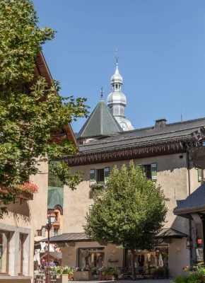 Village de megève avec une ruelle fleurie et le clocher