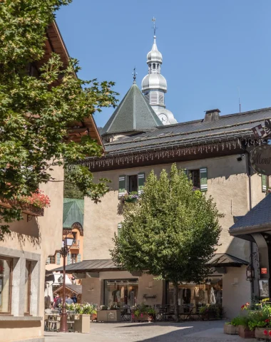 Village de megève avec une ruelle fleurie et le clocher